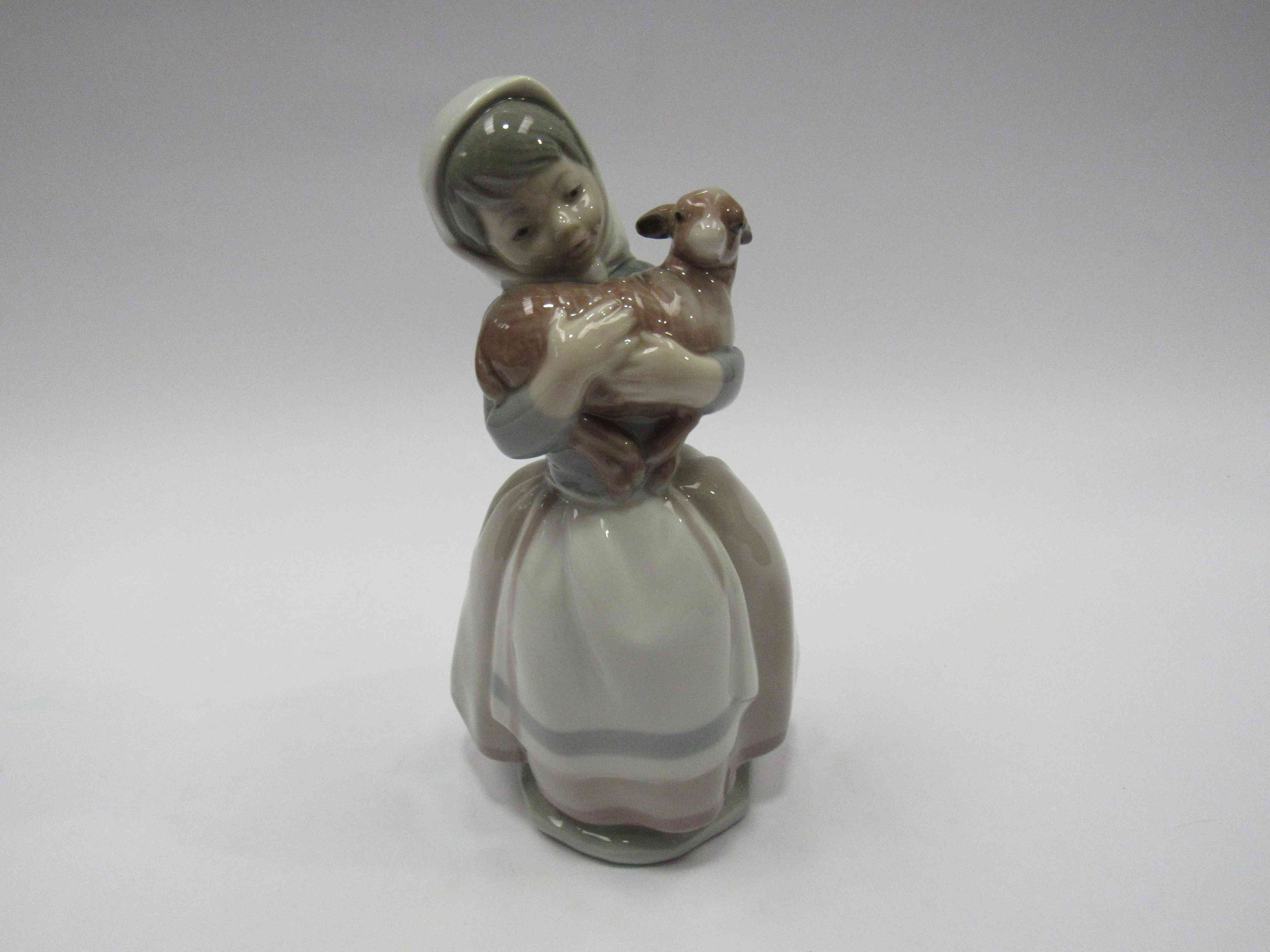 A Lladro figure of a girl holding a lamb,