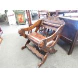 A low ecclesiastical chair with leather seat and back pad,