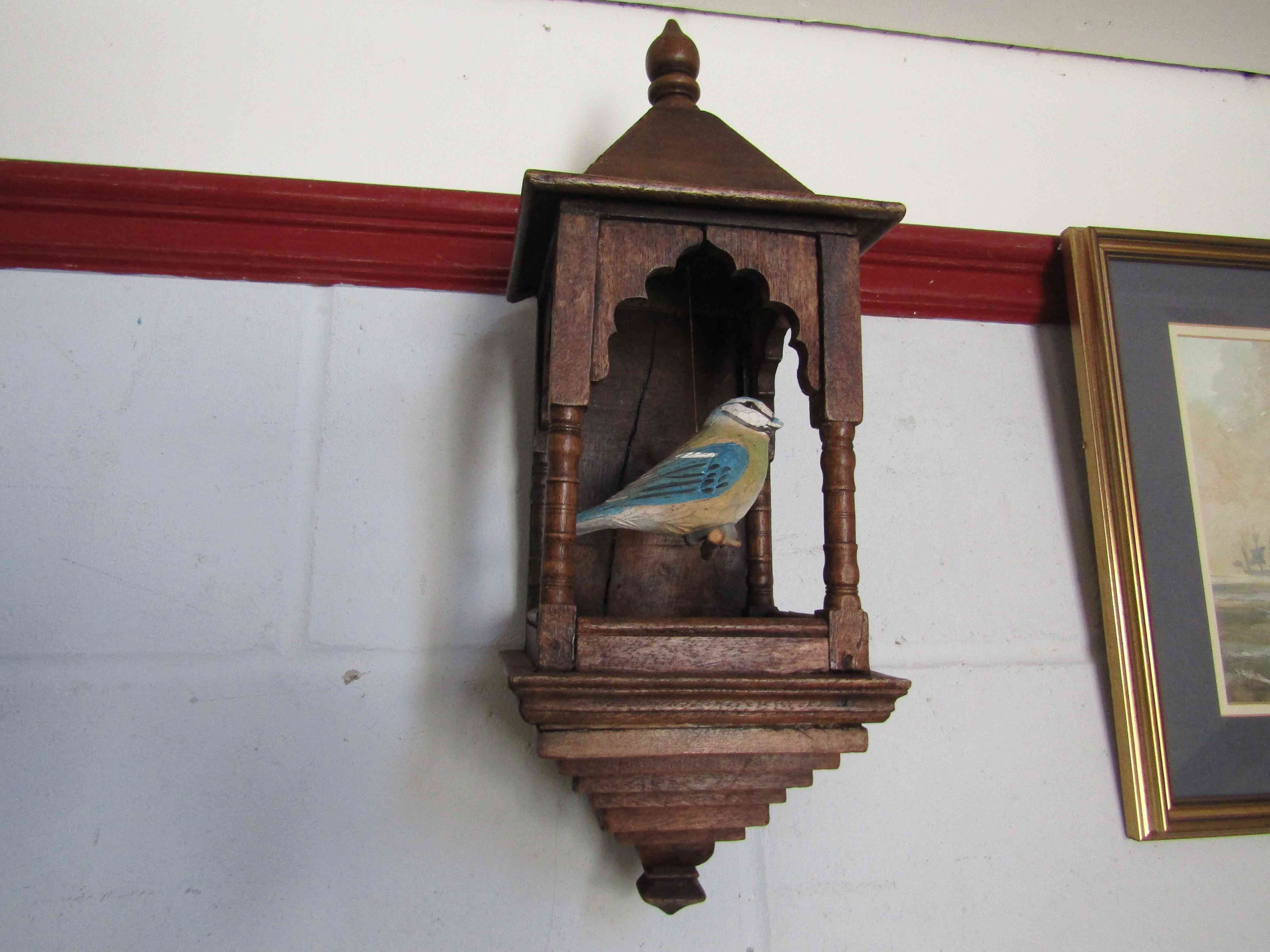 A wooden ornamental bird cage with blue tit figure,