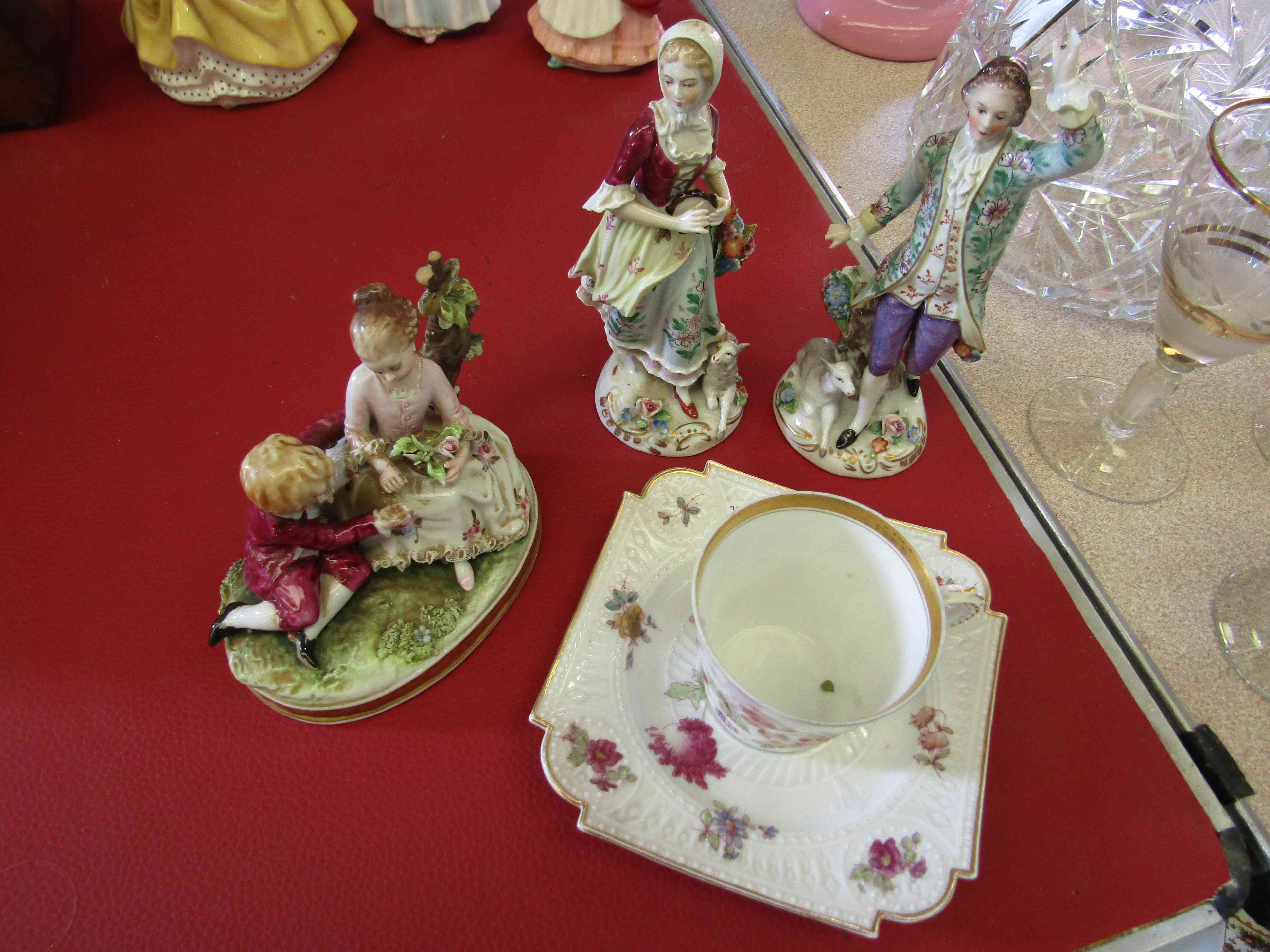 Three late 19th Century Continental porcelain figures and a cup and saucer