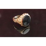 A 9ct gold onyx signet ring with textured shoulders. Size S/T, 5.
