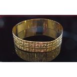 A gold bangle with starcut design, 16mm wide, misshapen,