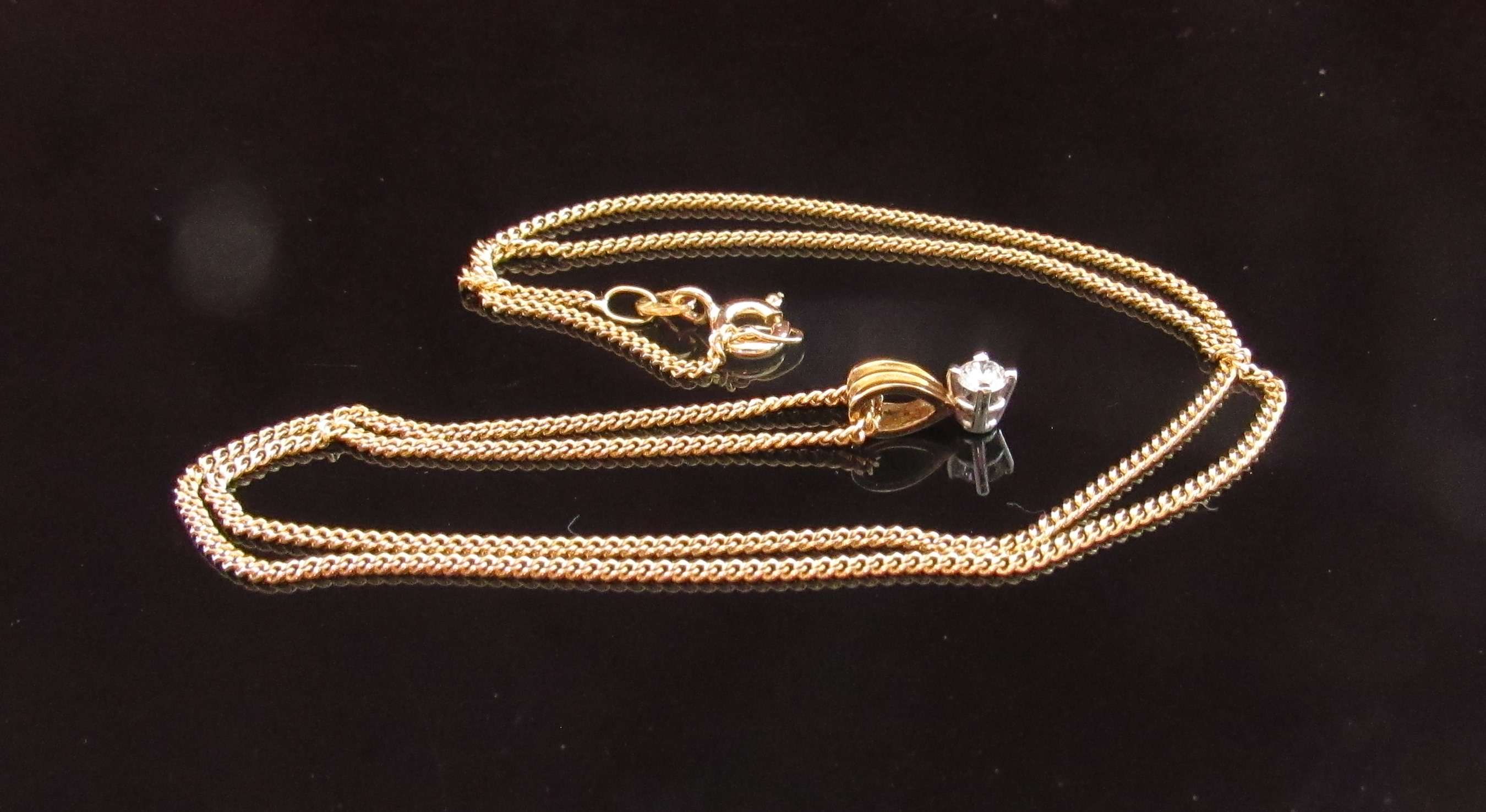 An 18ct gold necklace hung with a diamond pendant .10ct, 40cm long, 3.