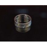 A white gold band 6mm wide stamped 18ct. Size O, 5.