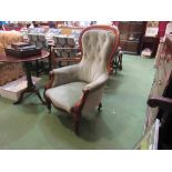 A Victorian walnut spoon back armchair with scroll carved decoration on turned tapering legs and