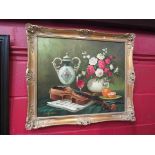 A gilt framed still life oil on canvas depicting violin, vase of flowers, fruit and wine,