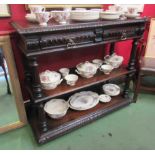 A mid Victorian oak three tier serving table with carved decoration the two frieze drawers over