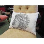 A cushion with images of Romans wearing laurel wreaths