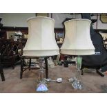 A pair of cut glass table lamps with cream shades,