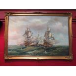 A gilt framed oil on canvas of battling galleons, signed lower right,