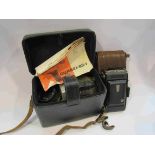 An Ikonta folding camera in brown leather case and a Quarzi x 85-I cine camera in case with