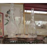 A silver plate galleried tray with five moulded and cut glass decanters