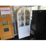 A modern white domed top glazed display cabinet on four drawer chest base,