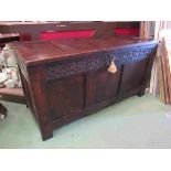 An 18th Century pegged oak panelled coffer with carved decoration,