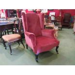 A late Victorian wing back armchair the scroll arms over cabriole legs and castors