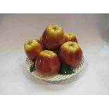 A Majolica style ceramic table centrepiece of apples in a lattice basket