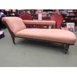 A Victorian chaise longue on turned legs to castors,