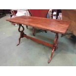 A walnut coffee table on trestle base,