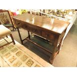 A 20th Century oak serving table with three drawers on stretcher base,