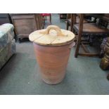 A terracotta egg crock with wooden lid