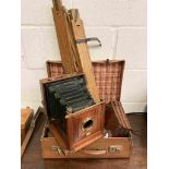 A late Victorian mahogany cased field camera with lens, tripod,