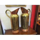 A pair of brass and copper wine jugs,