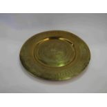 A brass dish with longboat design,