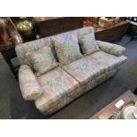 A 20th Century three seater sofa with floral upholstery