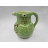 A puzzle jug signed by C.H. Brannam and dated 1899, decorated in pale green slip and initialled B.