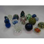 A collection of 15 glass paperweights including Mdina and Langham