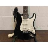 A Fender Squier 'Strat' electric guitar with black body, with whammy bar,