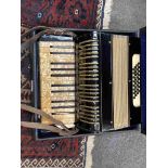 A 32 bass piano accordion with 25 keys, black and gold pearlescent design,