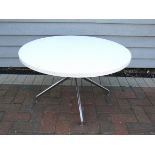 A white melamine circular top table on aluminium eames style legs,