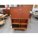 A Danish teak tall cabinet, twin sliding doors above open book/record shelves,