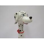 An Italian Pottery figure of a Dalmation wearing a red bow collar. Painted "Italy" to base.