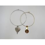 Two torc necklaces in gold and silver tones, one featuring a silver dipped skeletal leaf,