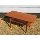 A Danish teak coffee table with undertier, raised on tapering legs, 99.