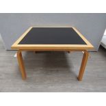 A Danish square coffee table by Magnus Olesen, laminated beech ply with inset black Linoleurn top,