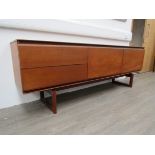 A 1970's teak long side cabinet with two drawers, fall front door and cupboard door,