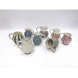 Eight 1950's Rye Pottery jugs with painted striped designs in various colours.