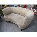 A 1940's Danish curved two seater sofa, original floral upholstery, raised on stained beech legs.