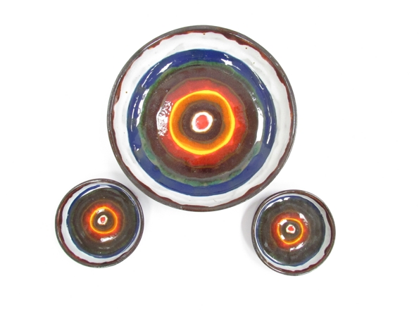 Three circular mid Century ceramic wall hangings with abstract design, one large and one small,