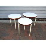 A nest of circular occasional tables, white mellamine top, stained teak finish edges,