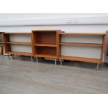 A Danish teak three section low open bookcase, raised on aluminium cylindrical legs. Two at 81.