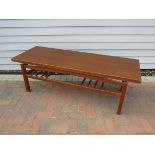 A Danish teak coffee table with 'floating top' and slatted undertier, raised on square legs.