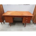 A Danish teak twin pedestal desk, cupboard to one, four drawer between, raised on tapering legs 129.