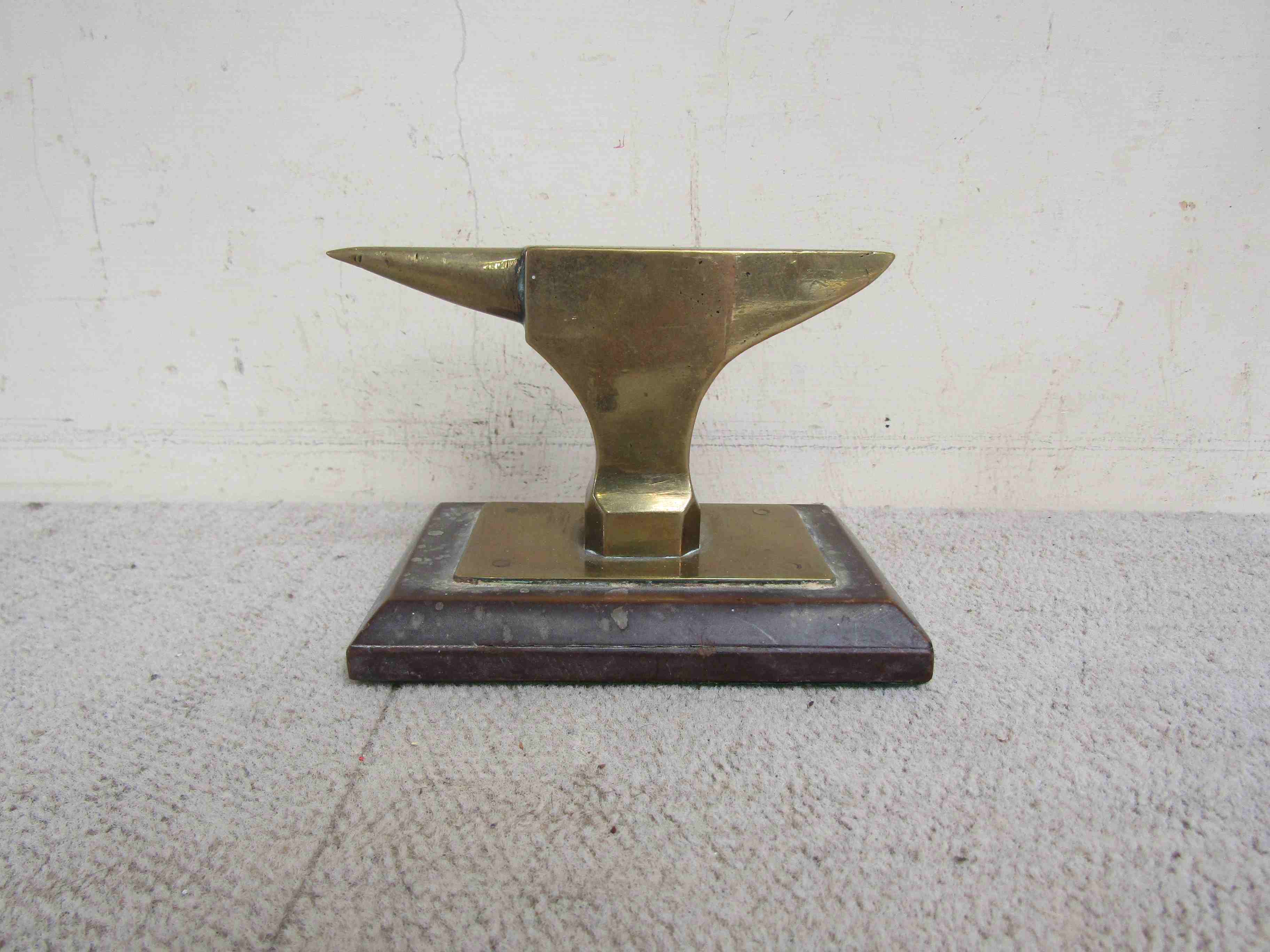 A brass anvil mascot mounted on a plinth