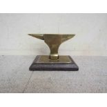 A brass anvil mascot mounted on a plinth