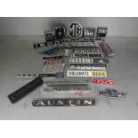 A box of mixed car badges including MG,