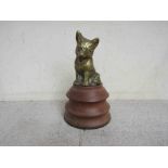 A brass seated fox cub mascot mounted on a turned plinth